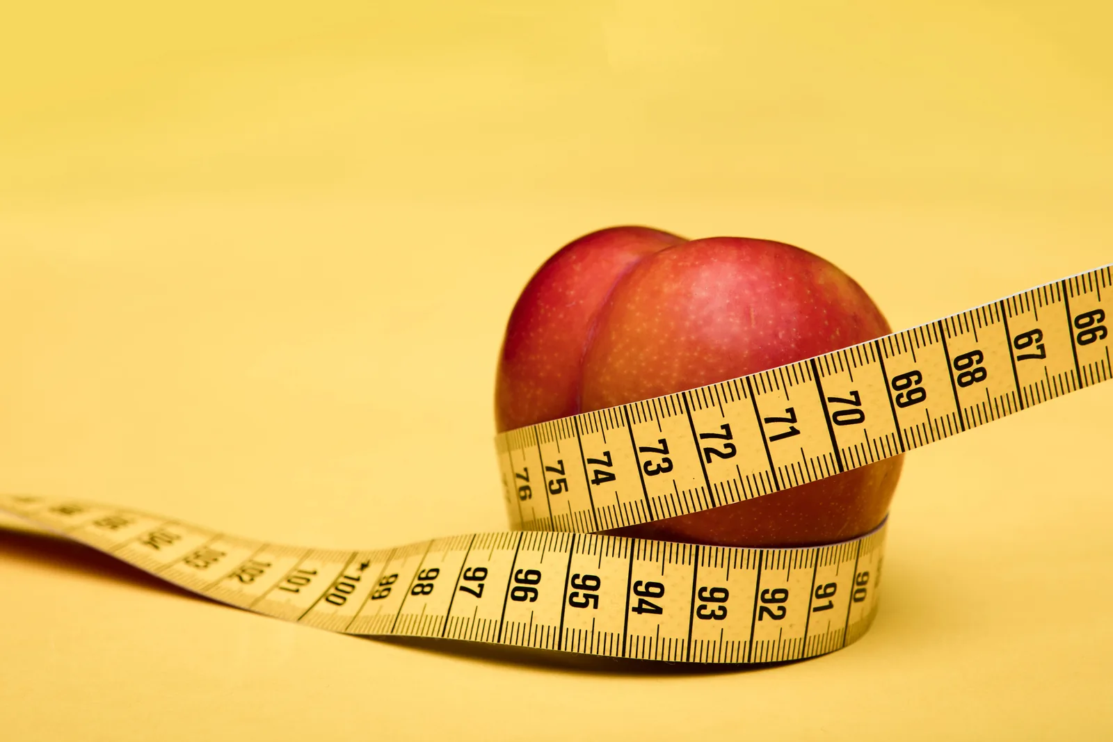 An apple wrapped in a tape measure