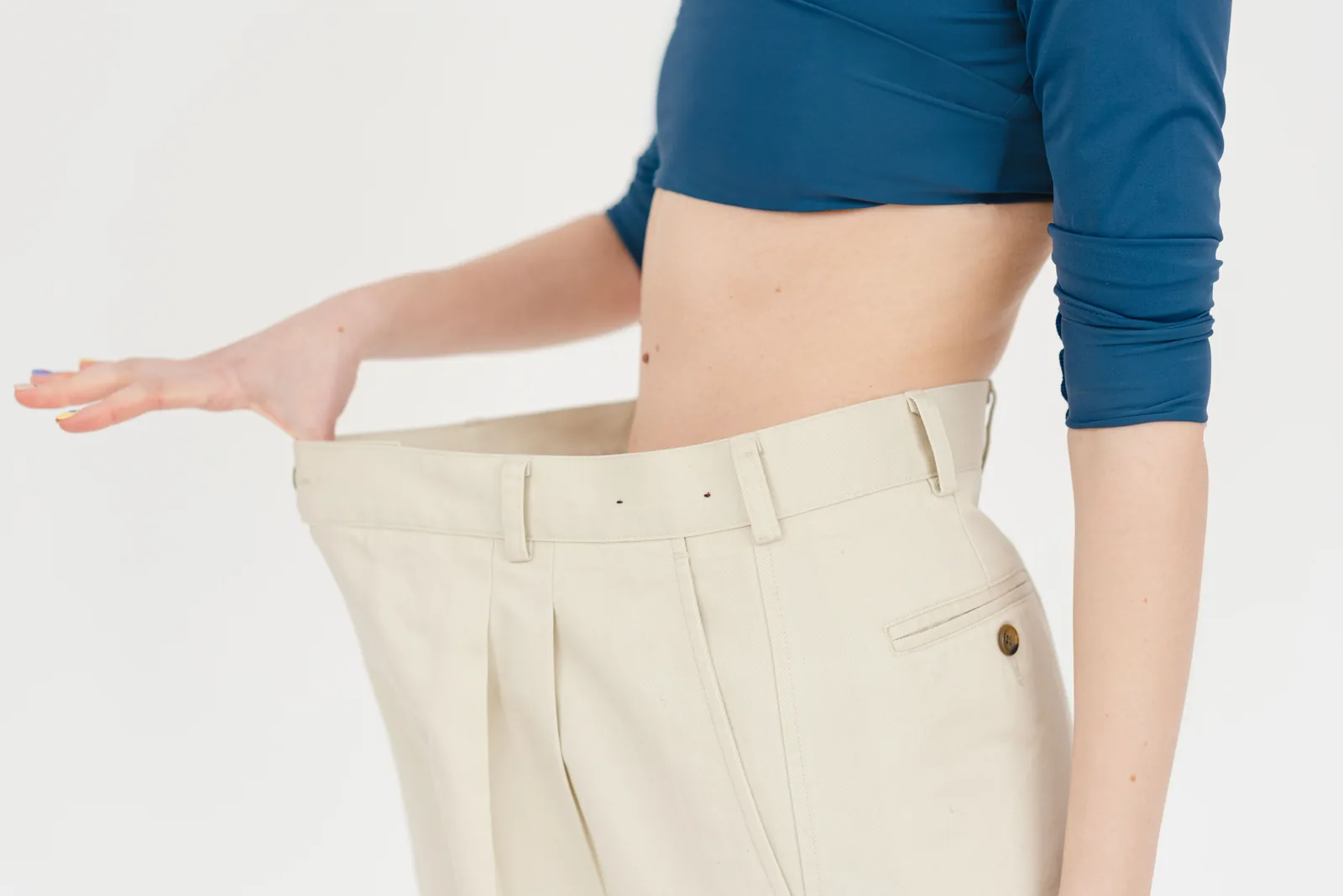 Loose trousers held away from the waist after weight loss