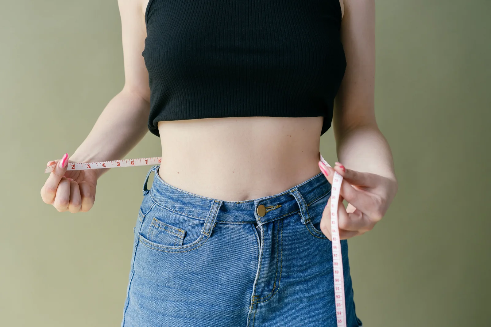 Measuring the waist over jeans with a tape measure