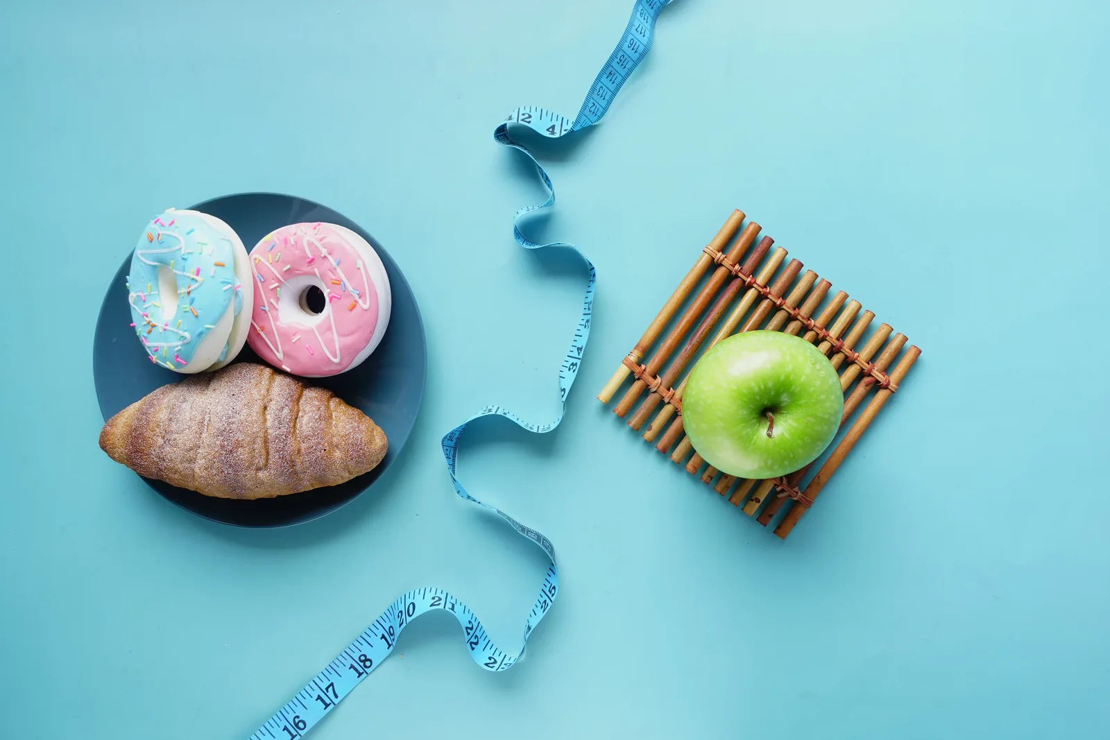 Pastries beside an apple with a tape measure