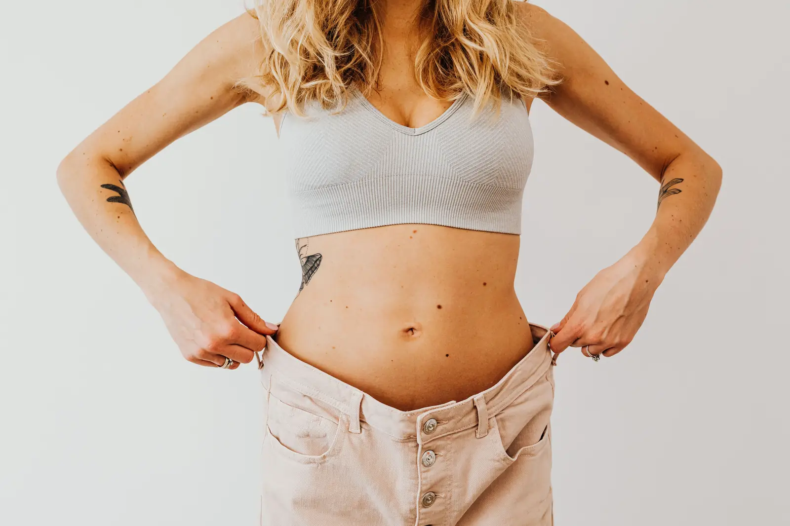 Holding out trousers that are now far too loose