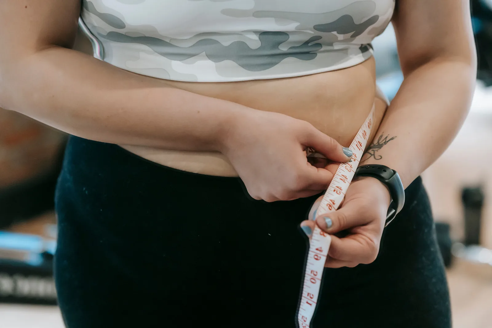 Waist being measured with a tape at the gym